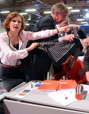 epa05333287 Chairwoman of Germany's Left Party, or Die Linke, Katja Kipping (L), and Left Party member of parliament Dietmar Bartsch (C) shield parliamentary leader of the Left Party Sahra Wagenknecht (R) after she was attacked with a cream cake at the party conference in Magdeburg, Saxony-Anhalt, Germany 28 May 2016. The Left Party is meeting for a two-day party congress. EPA/HENDRIK SCHMIDT
