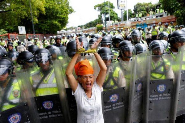 An opposition supporter shouts slogans in front of riot policemen during a rally to demand a referendum to remove President Nicolas Maduro in Caracas, Venezuela, June 7, 2016. REUTERS/Ivan Alvarado