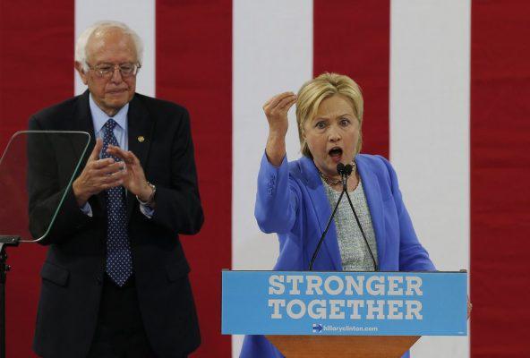 epa05422020 Democratic Presidential candidate Hillary Clinton (R) with former Democratic Presidential candidate Bernie Sanders as they appear together at an event at Portsmouth High School in Portsmouth, New Hampshire, USA, 11 July 2016. Sanders, who had run against Clinton in the Democratic Primary endorsed Clinton at the event. EPA/CJ GUNTHER