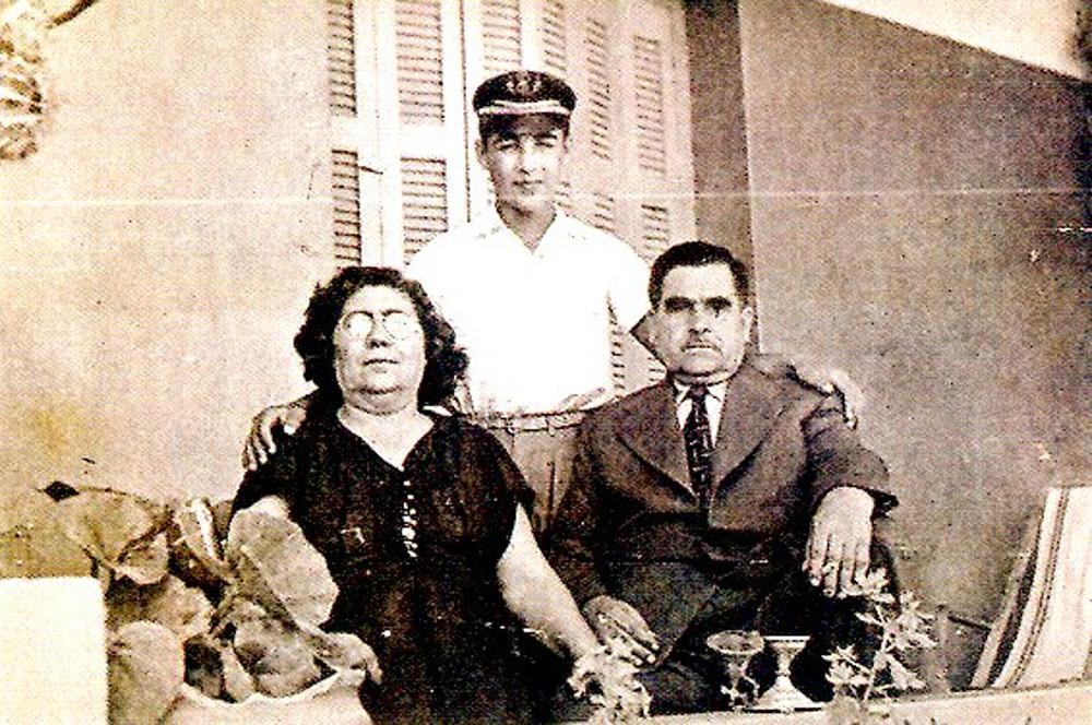 Ο Τόλης Βοσκόπουλος με σχολικό καπέλο και τους γονείς του στο σπίτι τους το 1952.