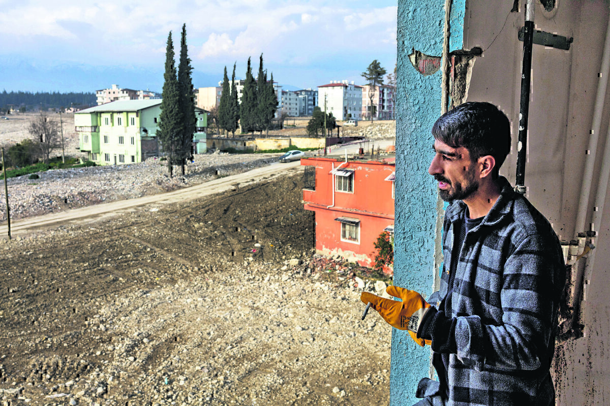 Ο Αχμέτ Αλτινόζ στέκεται προβληματισμένος πίσω από το παράθυρο στο σπίτι των γονιών του, οι οποίοι μόλις πήραν το μήνυμα από την κυβέρνηση που τους ειδοποιεί πως θα πρέπει να μεταφερθούν σε άλλη περιοχή, νοτιότερα στο Χατάι.