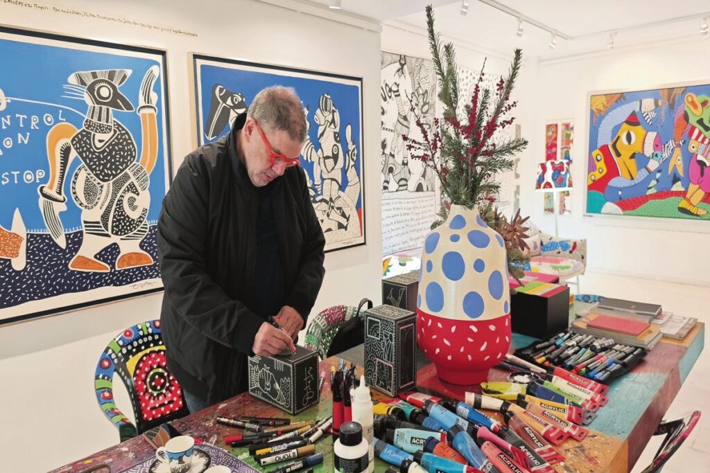 Ο Θανάσης Λάλας στο γεμάτο χρώμα γραφείο του, όπως μεταφέρθηκε στην γκαλερί Contemporary Athens.