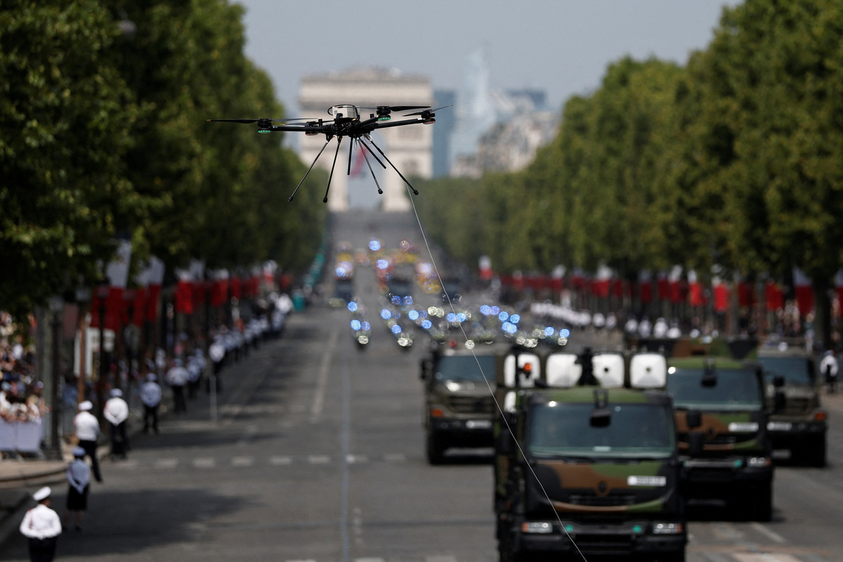 Ένα στρατιωτικό drone πετά πάνω από τη λεωφόρο των Ηλυσίων Πεδίων κατά τη διάρκεια της ετήσιας στρατιωτικής παρέλασης για την Ημέρα της Βαστίλης στο Παρίσι. REUTERS/Benoit Tessier