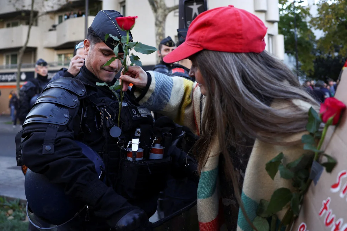 Διαδηλώτρια δίνει ένα λουλούδι σε αστυνομικό στις διαδηλώσεις στη Γαλλία.